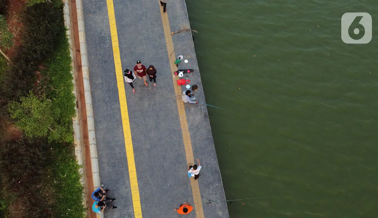Foto udara memperlihatkan aktivitas warga di pedestrian Danau Sunter, Jakarta, Sabtu (27/6/2020). Beragam aktivitas dilakukan warga sambil menikmati waktu sore di area Danau Sunter, Jakarta. (Liputan6.com/Helmi Fithriansyah)