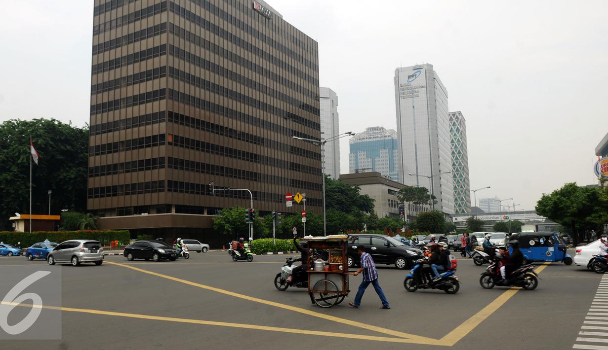 Sejumlah pengguna jalan melintas di perempatan Sarinah Jalan MH Thamrin, Jakarta, Senin (4/1/2016). Pasca libur panjang perayaan Natal 20015 dan Tahun Baru 2016, sejumlah ruas jalan ibukota mulai dipadati pengendara. (Liputan6.com/Helmi Fithriansyah)