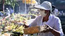 Umat Hindu meletakkan sesajinya di atas meja untuk merayakan Hari Raya Galungan di sebuah pura, Denpasar, Bali, Rabu 17 Juni 2026. (SONNY TUMBELAKA/AFP)
