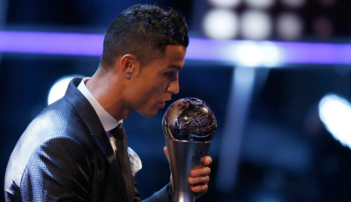 Bintang Real Madrid, Cristiano Ronaldo mencium trofi penghargaan pemain terbaik dalam acara The Best FIFA Football Awards 2017 di London, Senin (23/10). Ronaldo terpilih sebagai pemain terbaik menyisihkan Lionel Messi dan Neymar Junior (AP/Alastair Grant)