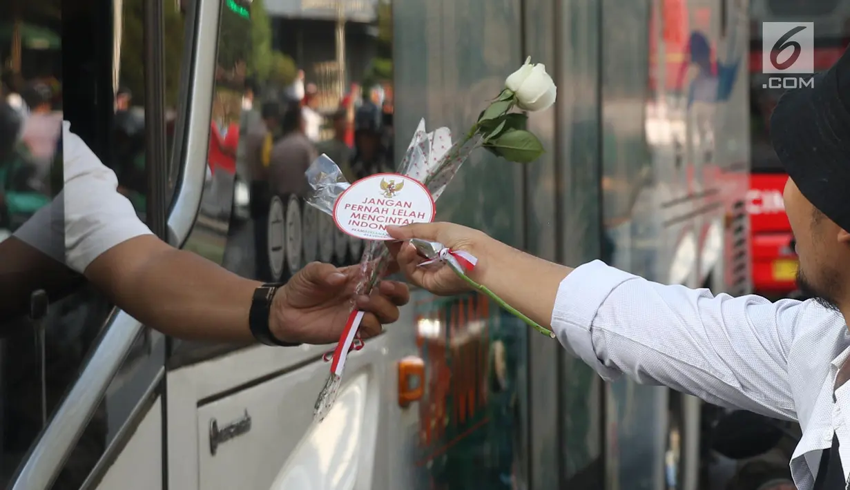 Relawan Jokowi saat membagikan bunga mawar di Kawasan Sarinah, Jakarta, Minggu (29/9/2019). Aksi bagi bunga tersebut merupakan aksi damai kami bersama Jokowi. (Liputan6.com/Angga Yuniar)