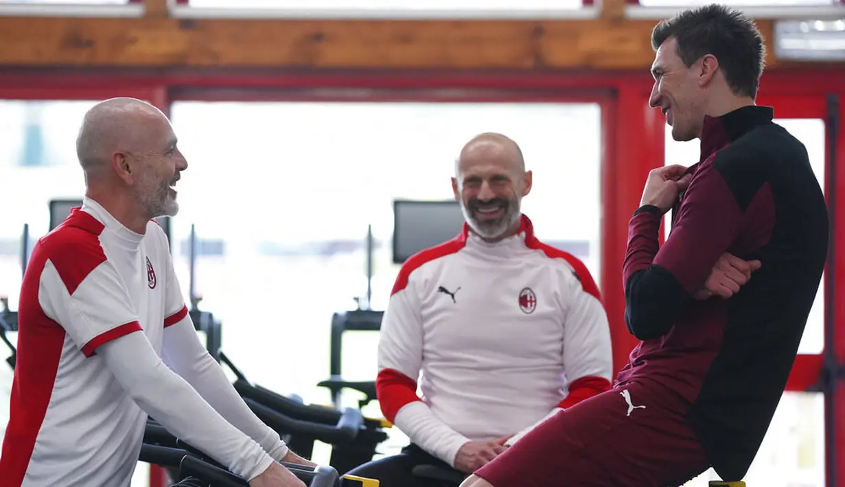 Striker baru AC Milan, Mario Mandzukic, berbincang dengan pelatih Stefano Pioli di Pusat Latihan AC Milan, Selasa (19/1/2021). Kehadiran Striker veteran asal Kroasia ini akan menambah ketajaman lini depan AC Milan. (Spada/LaPresse via AP)
