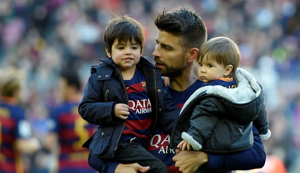 Gerard Pique bersama putranya, Milan dan Sasha, jelang melawan Real Sociedad dalam lanjutan La Liga Spanyol di Stadion Camp Nou, Barcelona, (28/11/2015). (AFP Photo/Lluis Gene)