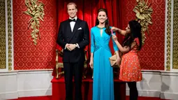Seorang pekerja Madame Tussauds tampak merapikan penampilan baru patung lilin Pangeran Williams dan Kate Middleton, London, Rabu (2/7/14). (AFP PHOTO/Leon Neal)