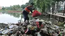 Petugas dari UPK Badan Air Dinas Lingkungan Hidup Provinsi DKI Jakarta saat membersihkan sampah di Waduk Ciracas, Jakarta, Selasa (8/1). Pembersihan ini dilakukan rutin setiap hari guna menjaga kebersihan waduk. (Merdeka.com/Iqbal S Nugroho)