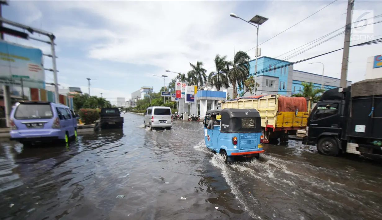 Sejumlah pengendara melitasi banjir rob di kawasan Muara Baru, Jakarta, Rabu (6/11). Banjir rob yang menggenangi kawasan ini setinggi 50 cm hingga 70 cm. (Liputan6.com/Faizal Fanani)