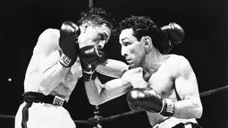 Willie Pep (kanan) memiliki rekor 229 kemenangan (65 KO) dan kalah 11 kali. Willie adalah juara kelas bulu pertama di dunia. Ini adalah saat Willie melawan petinju Prancis, Raymond Famechon di Madison Square Garden, New York, AS. (AFP/Intercontinentale)