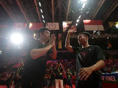 Pebulu tangkis ganda putra Indonesia, Mohammad Ahsan/Hendra Setiawan melakukan victory lap dalam acara 'Moment of Honor The Daddies' sebelum laga final Indonesia Masters 2025 di Istora Senayan, Jakarta, Minggu (26/01/2025). (Bola.com/Bagaskara Lazuardi)