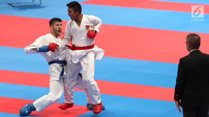 Karateka putra Indonesia, Rifki Ardiansyah Arrosyiid saat bertarung melawan karateka Iran, Amir Mahdi Zadeh di babak final nomor Kumite -60 kg di Arena Karate JCC Senayan, Jakarta, Minggu (26/8). Rifki menang dengan skor 9-7. (Liputan6.com/Fery Pradolo)