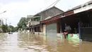 Warga duduk di pagar rumah saat banjir merendam perumahan Ciledug Indah, Tangerang, Banten, Kamis (2/1/2020). Memasuki hari kedua, kondisi perumahan tersebut masih tergenang banjir setinggi dada orang dewasa. (Liputan6.com/Angga Yuniar)