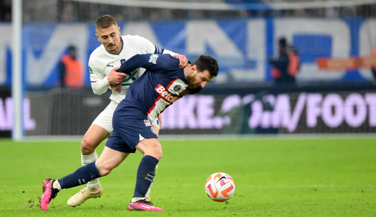 Pemain Paris Saint-Germain (PSG), Lionel Messi, diadang pemain Marseille, Valentin Rongier pada laga Piala Prancis di Stadion Stade Velodrome, Rabu (8/2/2022). Mereka takluk 1-2 saat berlaga di markas Marseille. (AFP/Christophe Simon)