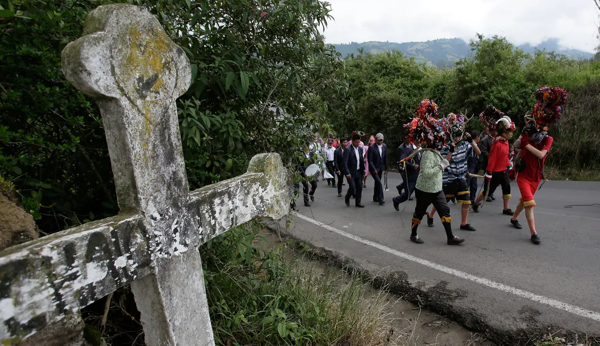 Orang-orang mengenakan topeng setan sambil menari selama festival  La Diablada di jalan-jalan kota Pillaro, Ekuador, Jumat (4/1). Anak-anak, pria, dan wanita memakai aneka pakaian menyeramkan menakut-nakuti orang-orang yang dilaluinya. (AP/Dolores Ochoa)