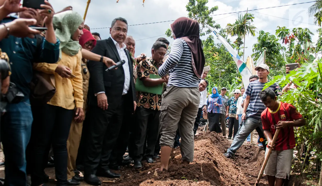 Menteri Desa Pembangunan Daerah Tertinggal dan Transmigrasi (Mendes PDTT) Eko Putro Sandjojo meninjau warga yang melakukan kegiatan padat karya tunai membuat gorong-gorong di Desa Bilalang Kota Kotamobagu, Sulawesi Utara, Kamis (12/4). (Liputan6.com/Pool)