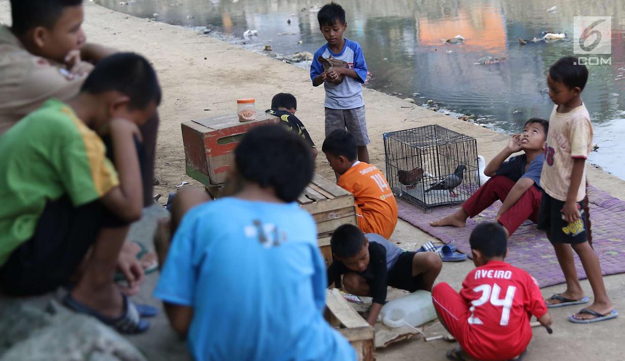 Anak-anak bermain di bantaran anak Sungai Ciliwung, Jakarta, Rabu (6/6). Meskipun tidak layak sebagai tempat bermain, namun lokasi itu menjadi tempat bagi anak-anak di kawasan tersebut untuk menunggu waktu berbuka. (Liputan6.com/Immanuel Antonius)