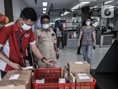 Petugas memeriksa kondisi paket sebelum proses pengiriman melalui jasa ekspedisi JNE di Tomang, Jakarta, Selasa (29/12/2020). Penggunaan jasa ekspedisi atau kurir meningkat hingga 85 persen selama pandemi COVID-19. (merdeka.com/Iqbal S. Nugroho)