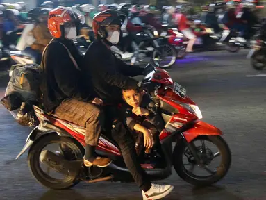 Pemudik yang menggunakan sepeda motor melintas di Jalan Raya Kalimalang, Bekasi, Jawa Barat, Rabu (19/4/2023) malam. (Liputan6.com/Herman Zakharia)