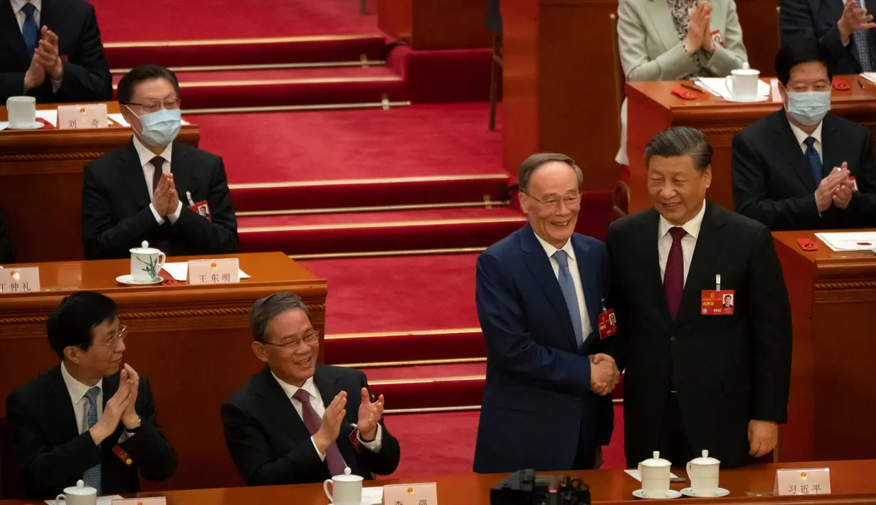 Presiden China Xi Jinping (kanan) berjabat tangan dengan Wang Qishan dalam sebuah sesi Kongres Rakyat Nasional China (NPC) di Aula Besar Rakyat di Beijing, Jumat, 10 Maret 2023. Pemimpin China Xi Jinping dianugerahi masa jabatan lima tahun ketiga sebagai presiden pada hari Jumat, dan tetap berkuasa di saat tantangan ekonomi yang parah dan meningkatnya ketegangan dengan AS serta negara-negara lain. (AP Photo/Mark Schiefelbein)