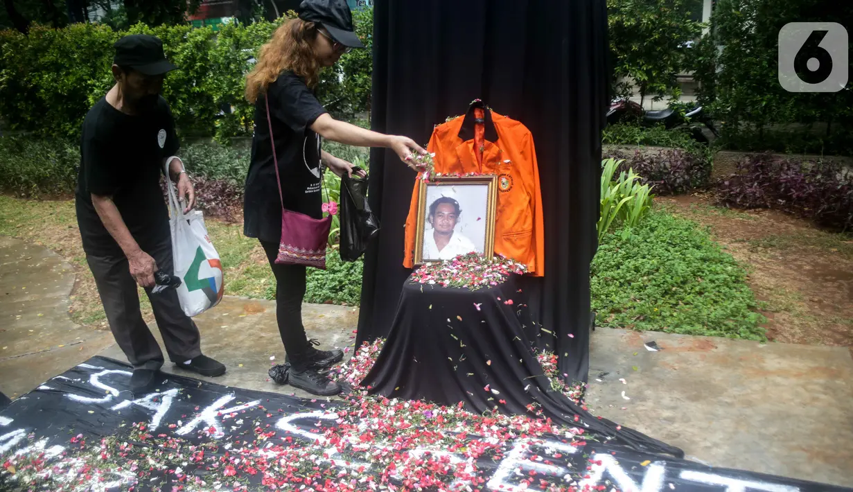 Aktivis menabur bunga pada foto Bernardus Realino Norma Wirawan dalam pada peringatan 21 Tahun Tragedi Semanggi I di halaman Universitas Atma Jaya, Jakarta, Rabu (13/11/2019). Mereka menuntut kepada Presiden mengusut tragedi yang hingga kini belum ada kejelasan hukumnya. (Liputan6.com/Faizal Fanani)