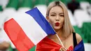 Fans Prancis berpose dengan memegang bendera saat menyaksikan laga Prancis melawan Tunisia pada laga Piala Dunia 2022 di Stadion Education City, Rabu (14/11/2022). (AFP/Franck Fife)