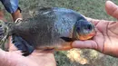 Seorang remaja, Kennedy Smith memperlihatkan ikan dengan gigi mirip gigi manusia yang ditangkapnya di kawasan Danau Fort Cobb, Oklahoma, 22 Juli 2018. (Tyler Howser/Oklahoma Department of Wildlife Services via AP)