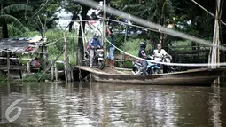 Sejumlah pengendara motor bersiap menaiki perahu eretan di  Kanal Banjir Barat (KBB), Teluk Gong, Jakarta, Rabu (10/2/2016). Dengan tarif Rp 2000, mereka dapat mempersingkat jarak dan waktu dari Teluk Gong menuju Pluit. (Liputan6.com/Faizal Fanani)