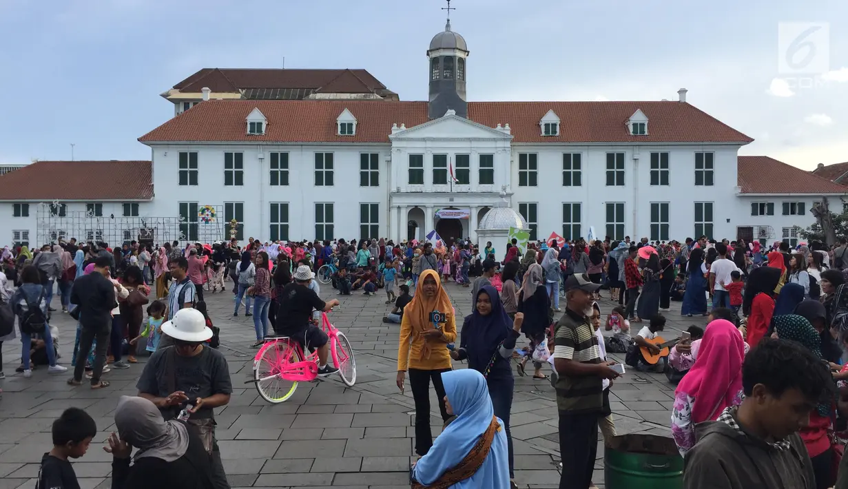 Wisatawan menikmati suasana kawasan Kota Tua, Jakarta, Jumat (16/2). Objek wisata sejarah Kota Tua menjadi salah satu tujuan warga Jakarta dan sekitarnya untuk mengisi libur Tahun baru Imlek 2018. (Liputan6.com/Immanuel Antonius)
