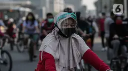 Warga berolahraga di area Car Free Day (CFD) kawasan MH Thamrin, Jakarta, Minggu (21/6/2020). Kegiatan hari bebas kendaraan bermotor atau CFD Jakarta kembali dibuka pada Minggu (21/6) ini diiringi dengan sejumlah protokol kesehatan. (Liputan6.com/Johan Tallo)