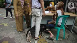 Paramedis Puskeswan DKP3 Jakarta Selatan melakukan pendataan saat pelaksanaan vaksinasi antirabies secara gratis di kawasan Tebet, Jakarta, Selasa (16/11/2021). Vaksinasi juga dilakukan agar Provinsi DKI Jakarta bebas rabies. (Liputan6.com/Faizal Fanani)