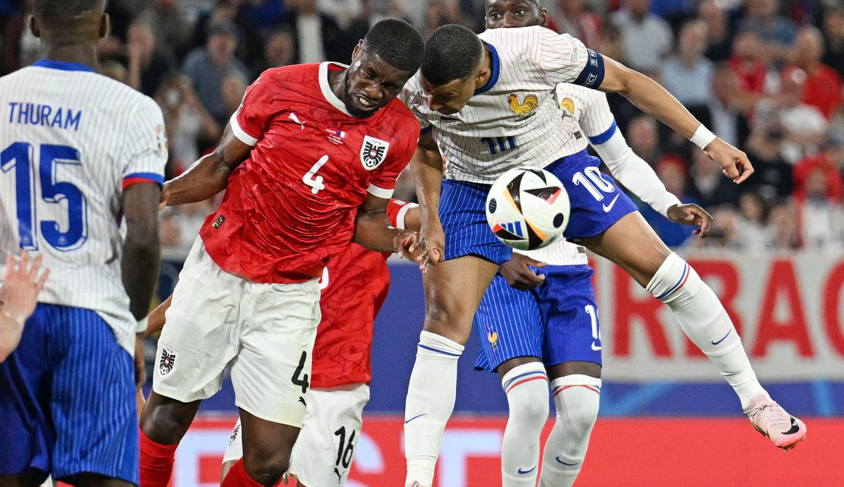 Insiden itu terjadi pada menit akhir pertandingan. Mbappe yang berusaha menyundul bola di kotak penalti justru menanduk bahu bek Austria, Kevin Danso. (AFP/Patricia De Melo Moreira)
