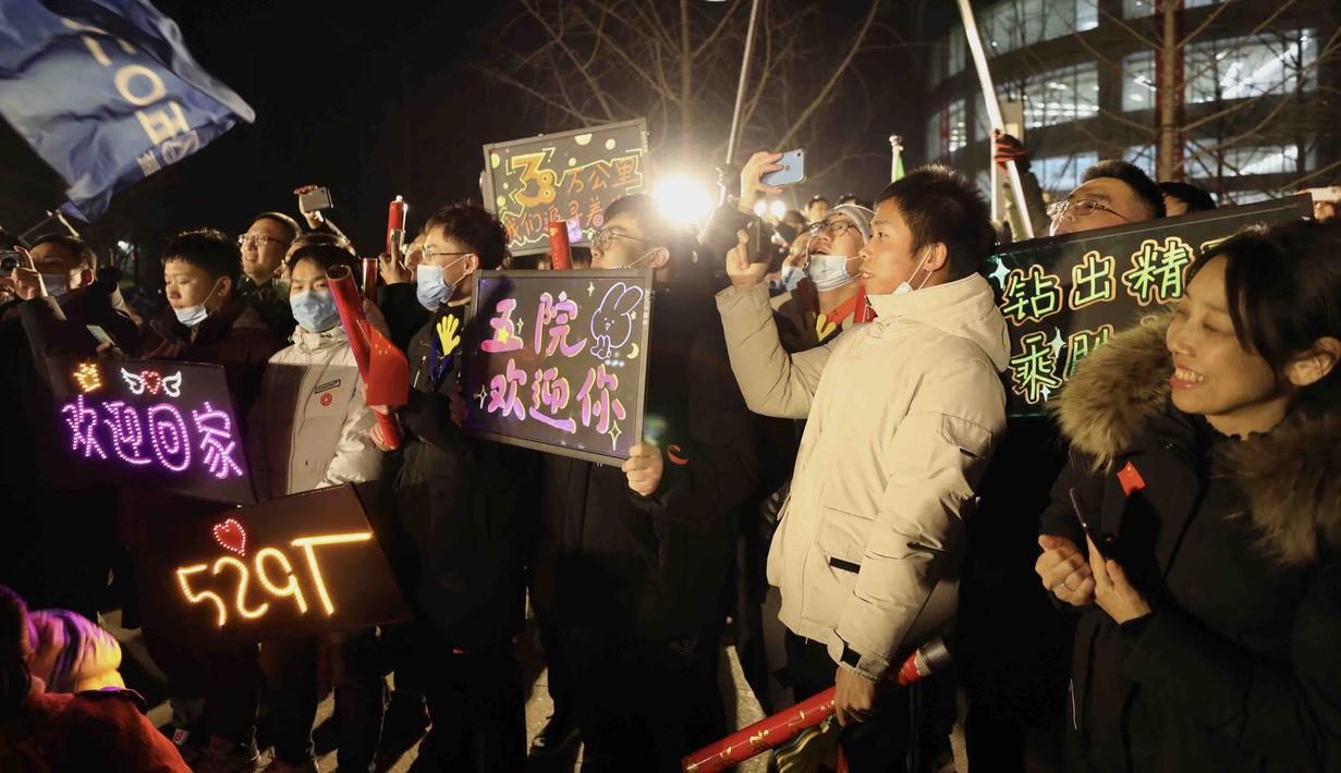 Orang-orang merayakan kedatangan kapsul pembawa pulang (return capsule) wahana antariksa China, Chang'e-5, di Akademi Teknologi Luar Angkasa China di Beijing, China (17/12/2020). Kapsul pembawa pulang wahana antariksa China tersebut mendarat di Bumi pada Kamis (17/12) dini hari. (Xinhua/Jin Liwang)