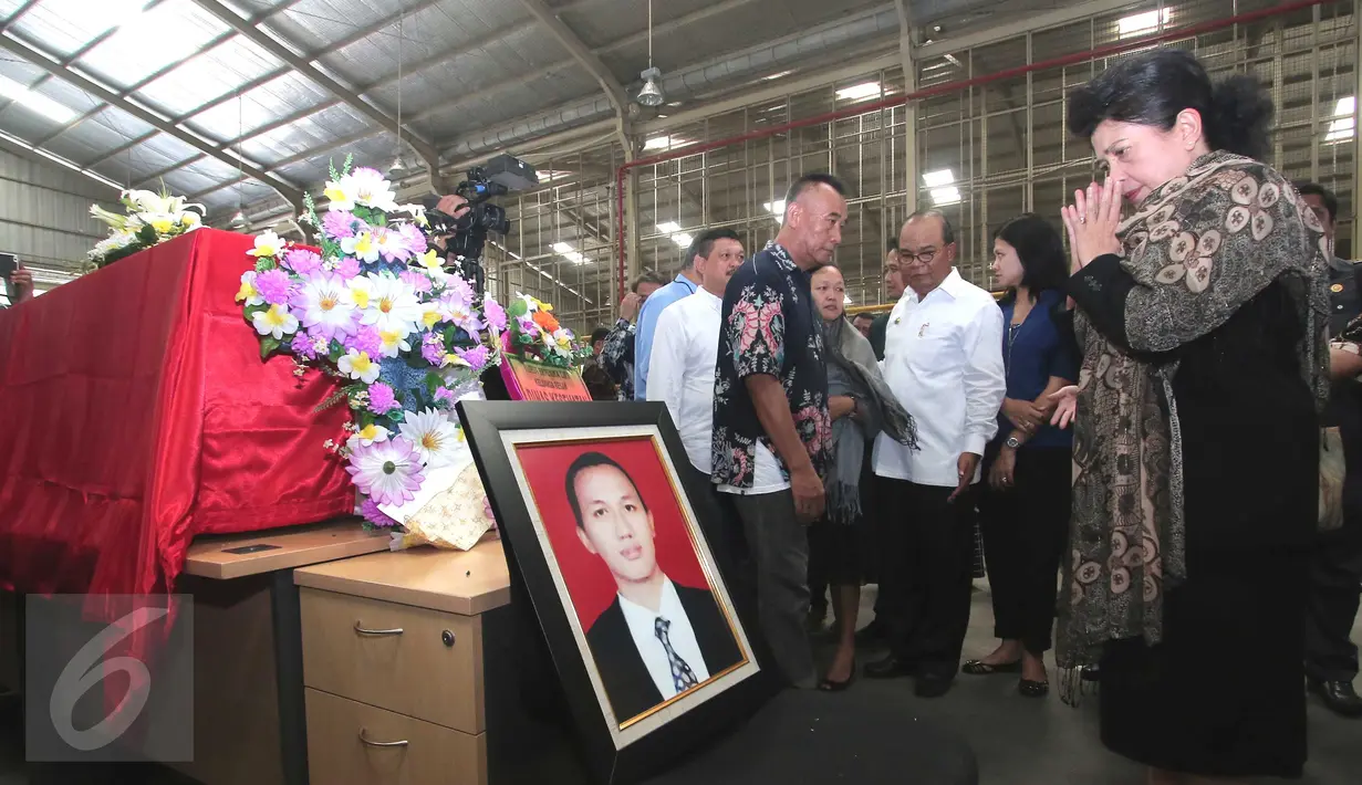 Menkes Nila F Moeloek (kanan) berdoa di depan peti jenazah Dionisius Giri Samudra atau dokter Andra di Bandara Soekarno Hatta, Tangerang, Jumat (13/11). Andra meninggal saat bertugas di Kota Dobo, Kepulauan Aru, Maluku.  (Liputan6.com/Angga Yuniar)