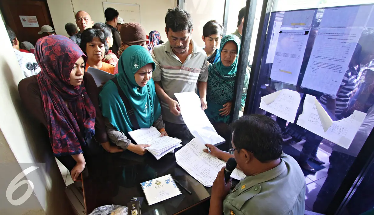 Petugas memanggil warga yang ingin membuat akte kelahiran dan e-KTP di Jakarta Timur, Senin (28/12). Proses pengurusan yang lebih mudah membuat warga membuat akte dan e-KTP jelang pergantian tahun. (Liputan6.com/Immnuel Antonius)