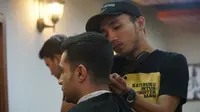 Pekerja di salah satu tempat pangkas rambut di Kota Bandung sedang mencukur rambut seorang pelanggan, Senin (5/8/2019). (Liputan6.com/Huyogo Simbolon)