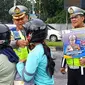Direktur Lalu Lintas Polda Riau Kombes Taufik Lukman membagikan helm kepada masyarakat agar sadar pentingnya melindungi kepala saat berkendara di jalan raya. (Liputan6.com/M Syukur)