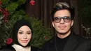 Aurel Hermansyah mengenakan long dress hitam dengan aksen putih di bagian dada dipadukan kerudung hitam polos. Didampingi Atta yang mengenakan jas hitam. [@aurelie.hermansyah]