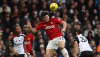 Pemain MU, Harry Maguire (tengah, berhasil mengamankan bola di udara dari jangkaun pemain Fulham dalam pekan ke-11 Premier League 2023/2024 yang berlangsung di Stadion Craven Cottage, London, Sabtu (4/11/2023) malam WIB. (AFP/Adrian Dennis)
