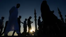 Diresmikan pada 10 Mei 2019 oleh Dr. Sheikh Sultan bin Muhammad Al Qasimi, masjid ini merupakan salah satu mahakarya arsitektur Islam modern yang paling menonjol di kawasan tersebut. Tampak dalam foto, para jamaah Muslim tampak berbayang saat tiba untuk berbuka puasa selama bulan suci Ramadan di Masjid Agung Sharjah, dekat Dubai, Uni Emirat Arab, Jumat 27 Februari 2026. (AP Photo/Altaf Qadri)