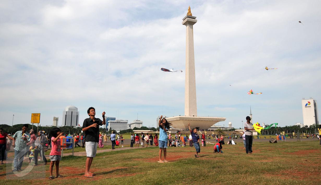 Sejumlah pengunjung bermain layang-layang di kawasan Monas, Jakarta, Sabtu (26/12/2015). Libur Natal dimanfaatkan sejumlah warga untuk berwisata ke tempat yang menjadi ikon Jakarta tersebut. (Liputan6.com/Yoppy Renato)