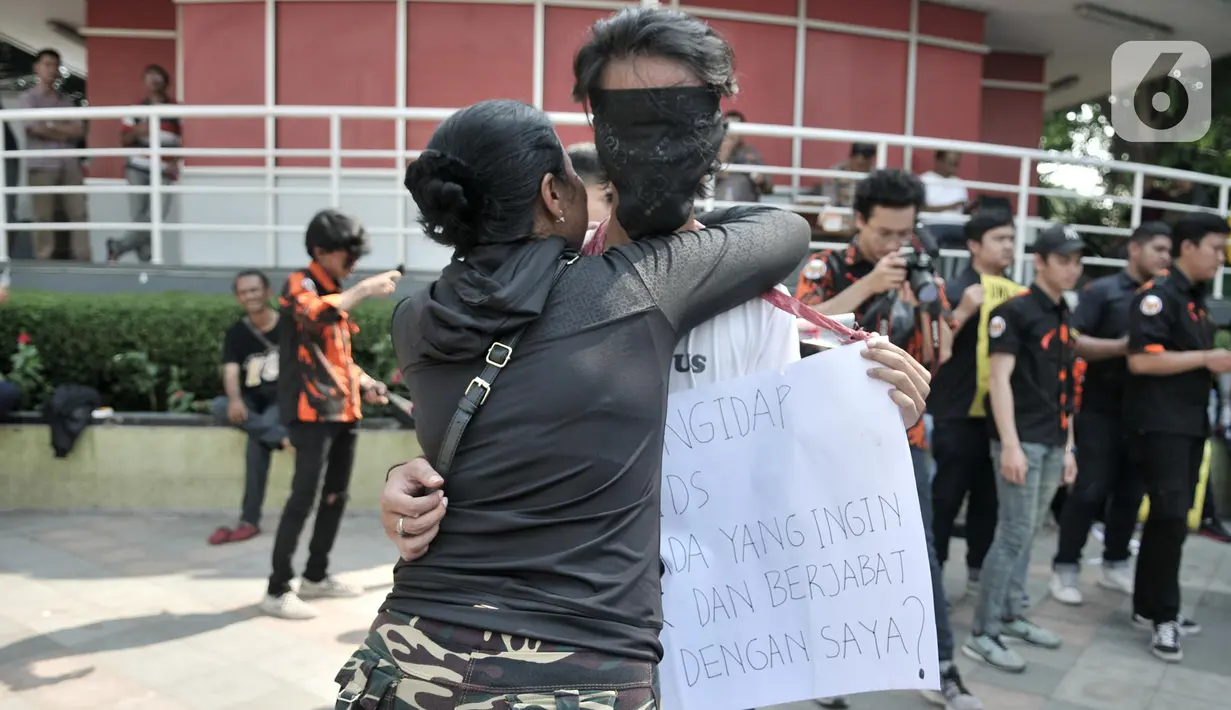 Seorang wanita memeluk pria penderita AIDS saat eringatan Hari AIDS Sedunia di Bundaran HI, Jakarta, Minggu (1/12/2019). Kegiatan ini bertujuan mengedukasi masyarakat tentang penyakit AIDS dan mengajak untuk peduli serta tidak menjauhkan penderita AIDS. (merdeka.com/Iqbal S. Nugroho)