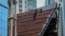 Aktivitas pekerja di atas atap gereja tanpa alat pengaman lengkap, Jakarta, Rabu (12/2/2020). Kemnaker mengatakan tingginya angka kecelakaan kerja di Indonesia disebabkan tidak maksimalnya penerapan K3 yang diatur dalam UU No1 Tahun 1970 tentang Keselamatan Kerja. (Liputan6.com/Faizal Fanani)