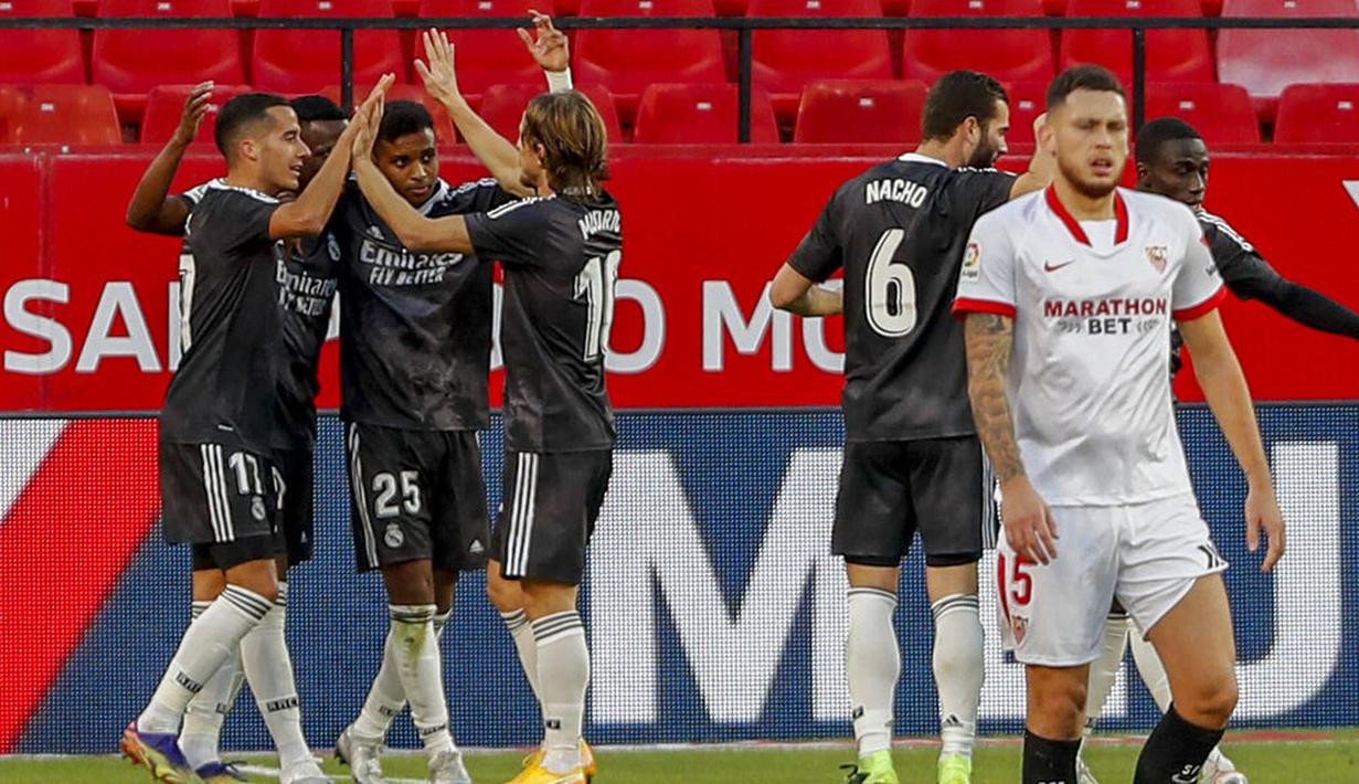 Para pemain Real Madrid merayakan gol yang dicetak ke gawang Sevilla pada laga Liga Spanyol di Stadion Ramon Sanchez Pizjuan, Minggu (6/12/2020). Real Madrid menang dengan skor 1-0. (AP/Angel Fernandez)