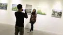 Pengunjung berfoto di depan karya yang dipajang dalam pameran bersama bertajuk 'Mutual Unknown' di Galeri Nasional, Jakarta, Sabtu (3/6). (Liputan6.com/Immanuel Antonius)