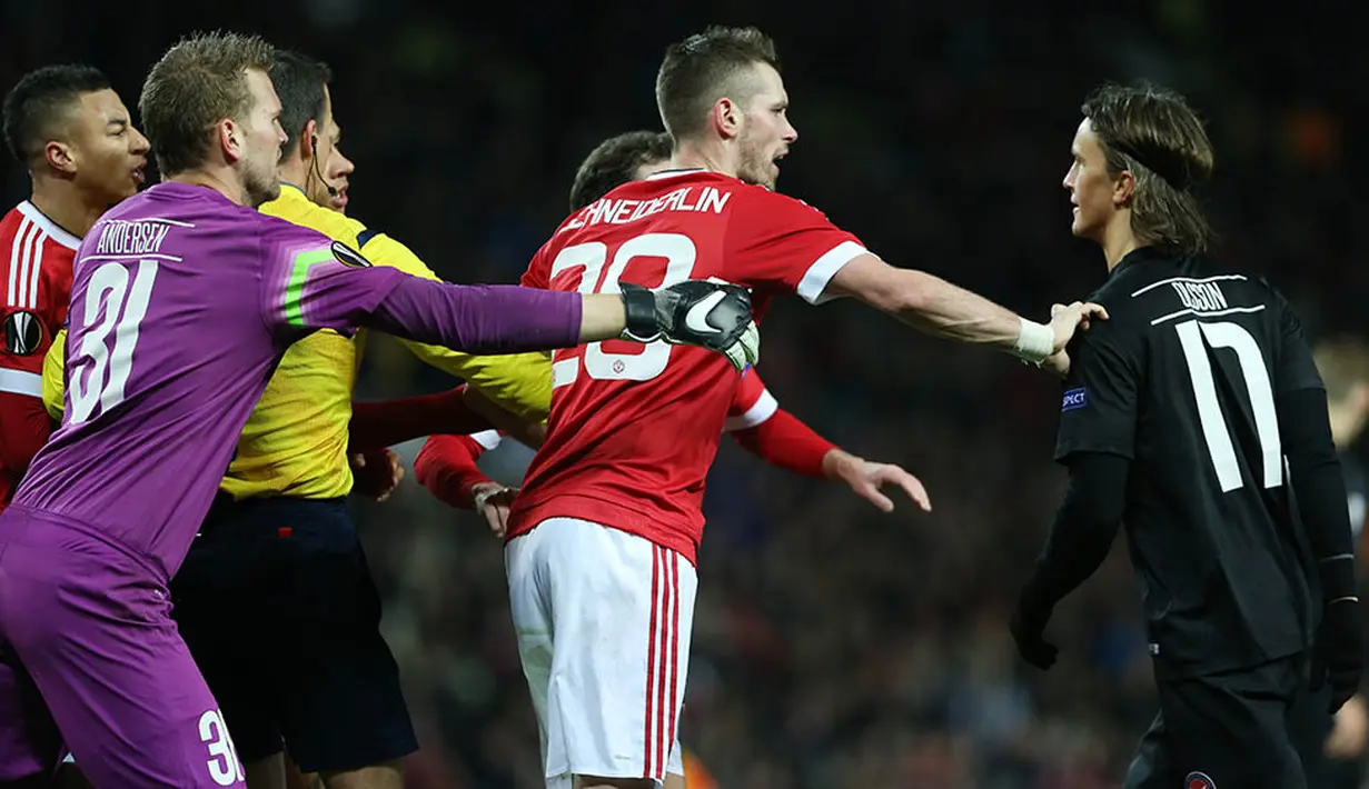 Gelandang Manchester United, Morgan Schneiderlin, berebut bola dengan pemain Midtjylland, Kris Olsson.  Pada laga itu wasit mengeluarkan tiga kartu kuning dan satu kartu merah. (Reuters/Russell Cheyne)