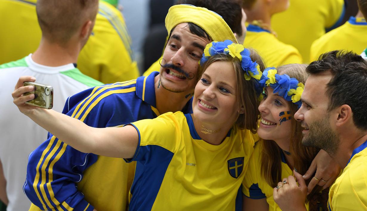 Fans Swedia melakukan selfie sebelum menyaksikan laga timnya melawan Irlandia pada Grud E Euro 2016 di Stadion Stade de France, Saint-Denis, (13/6/2016). (AFP/Paul Ellis)