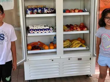 Dua orang anak berpose di depan kulkas yang berisi makanan dan minuman jelang bulan Ramadan di Dubai. Di Dubai setiap bulan Ramadan warga dan donatur mengisi kulkas yang berisi makanan dan minuman untuk berbuka puasa. (www.instagram.com/ramadanfridgesdxb)