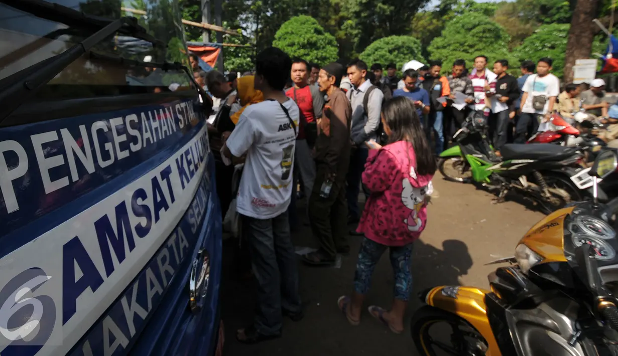 Warga mengantri di Gerai Pelayanan Samsat Keliling di Jalan Kalibata Raya, Jakarta, Senin (11/7). Pasca libur lebaran 2016, gerai Samsat Keliling kembali beroperasi melayani pembayaran pajak kendaraan bermotor. (Liputan6.com/Helmi Fithriansyah)