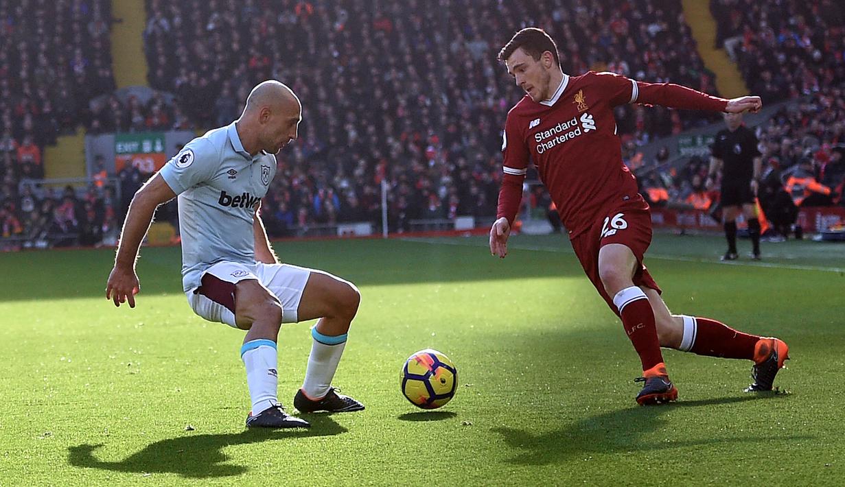 Aksi pemain Liverpool, Andrew Robertson (kanan) mengecoh pemain West Ham, Pablo Zabaleta pada laga Premier League pekan ke-28 di Anfield Stadium, Liverpool, (24/2/2018). Liverpool menang 4-1. (AFP/Oli Scarff)