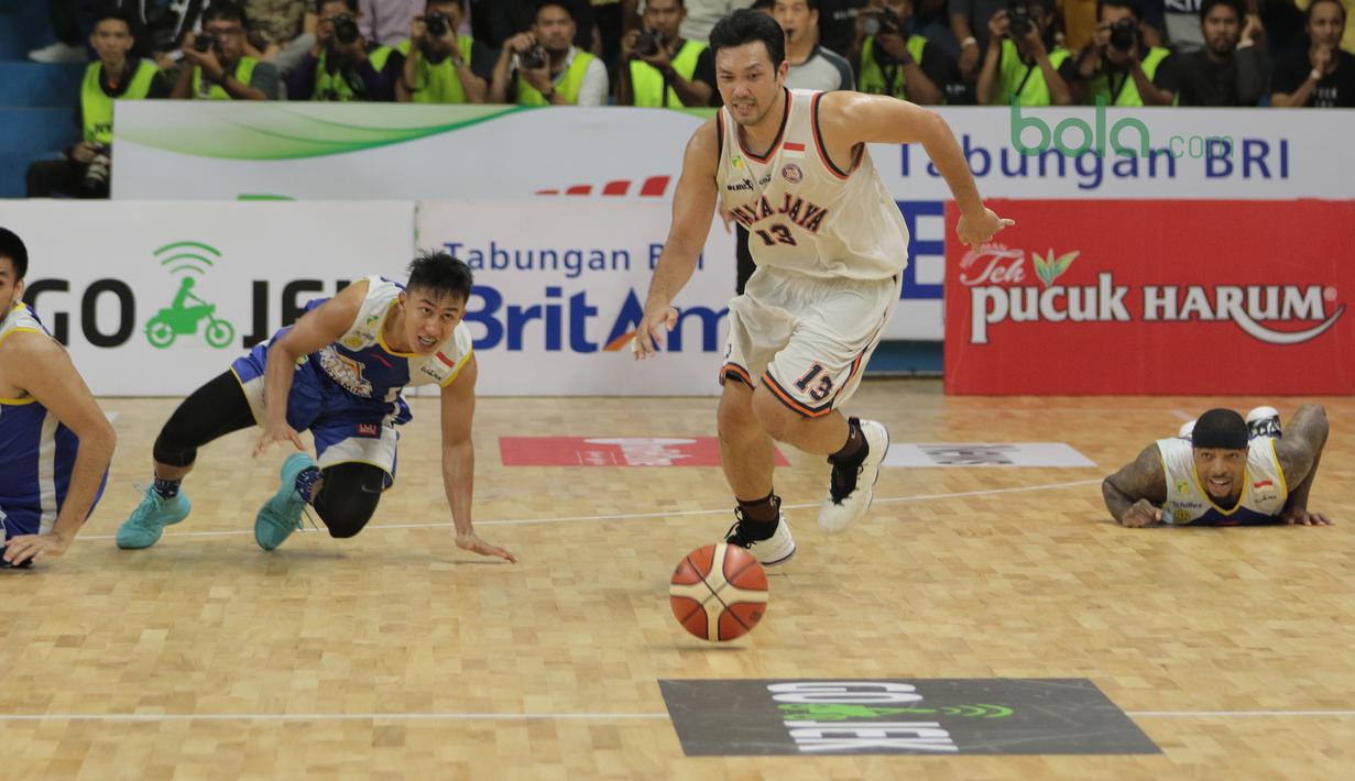 Pemain Pelita Jaya, Ponsianus Indrawan (2kanan) berebut bola dengan tiga pemain Satria Muda pada Final IBL 2018 di GOR Sumantri Brojonegoro, Jakarta, Minggu (22/4/2018). Satria Muda menang atas Pelita Jaya dengan skor 69-64. (Bola.com/Nick Hanoatubun)