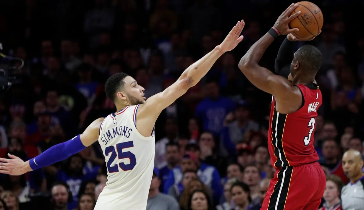 Pemain Miami Heat, Dwyane Wade melakukan tembakan saat diadang pemain Philadelphia 76ers, Ben Simmons pada NBA basketball playoff series di Wells Fargo Center, Philadelphia, (16/4/2018). Heat menang 113-103. (AP/Chris Szagola)