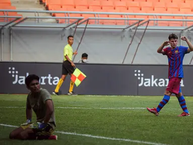 Pemain Barcelona U-18 Jan Molina Vilaseca (kanan) melakukan selebrasi usai mencetak gol ke gawang Bali United U-18 pada pertandingan International Youth Championship (IYC) 2021 di Jakarta International Stadium (JIS), Jakarta, Minggu (17/4/2022). Barcelona U-18 menang 3-0.(Liputan6.com/Faizal Fanani)